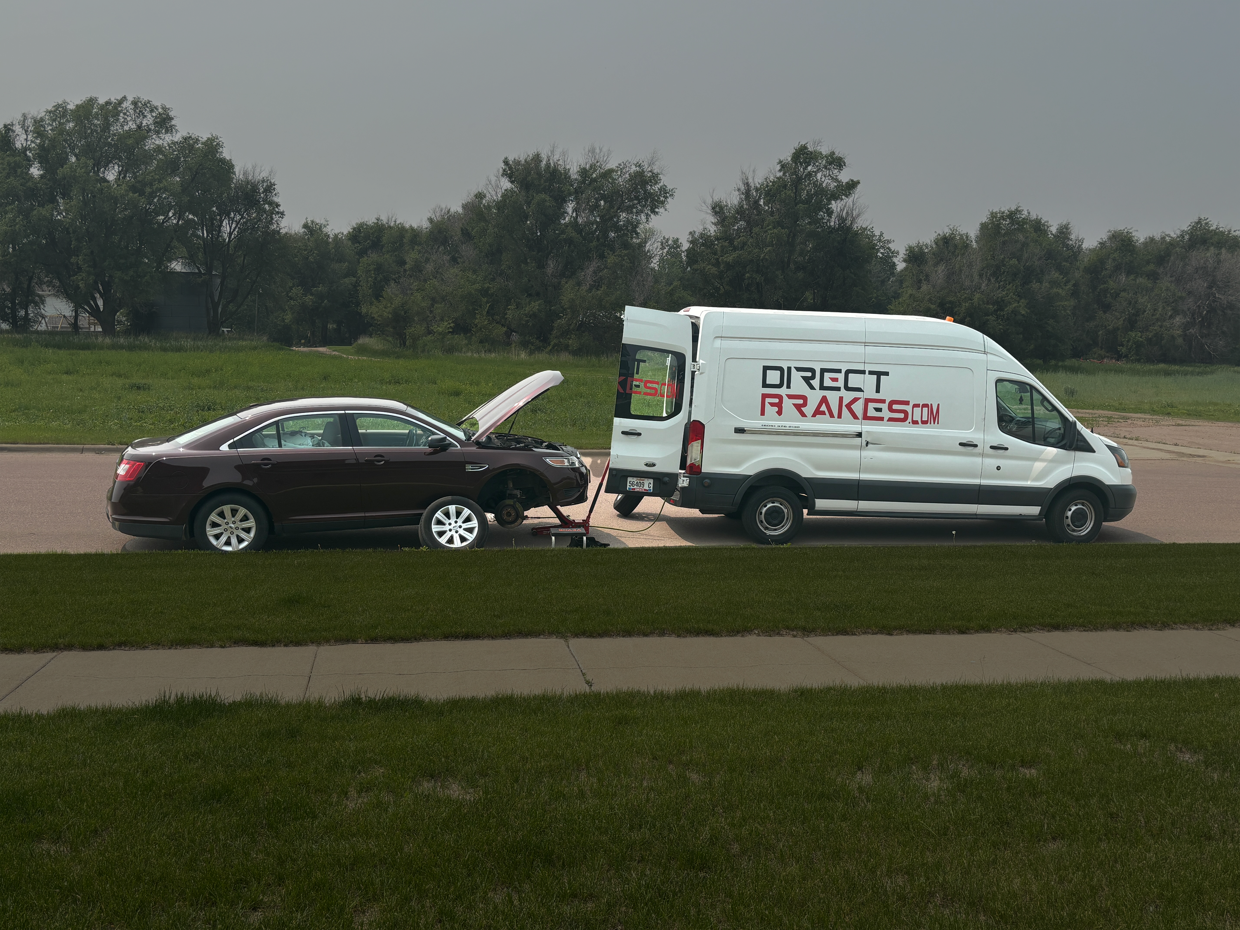 Mobile mechanic performing brake pad replacement