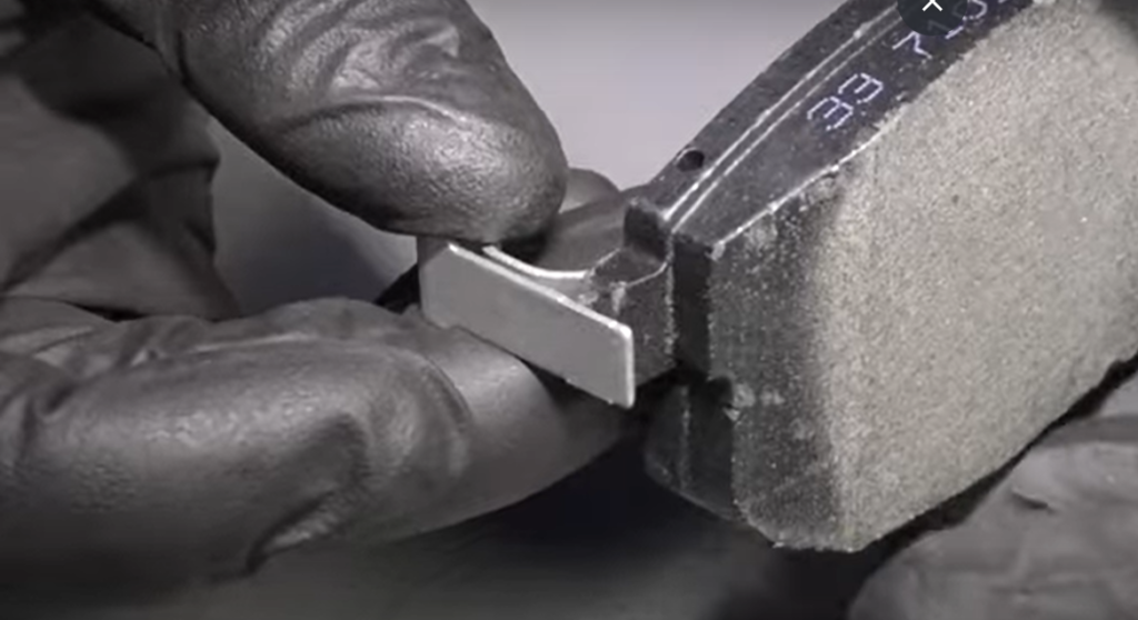 Close-up of worn brake pad and rotor showing signs of heavy wear