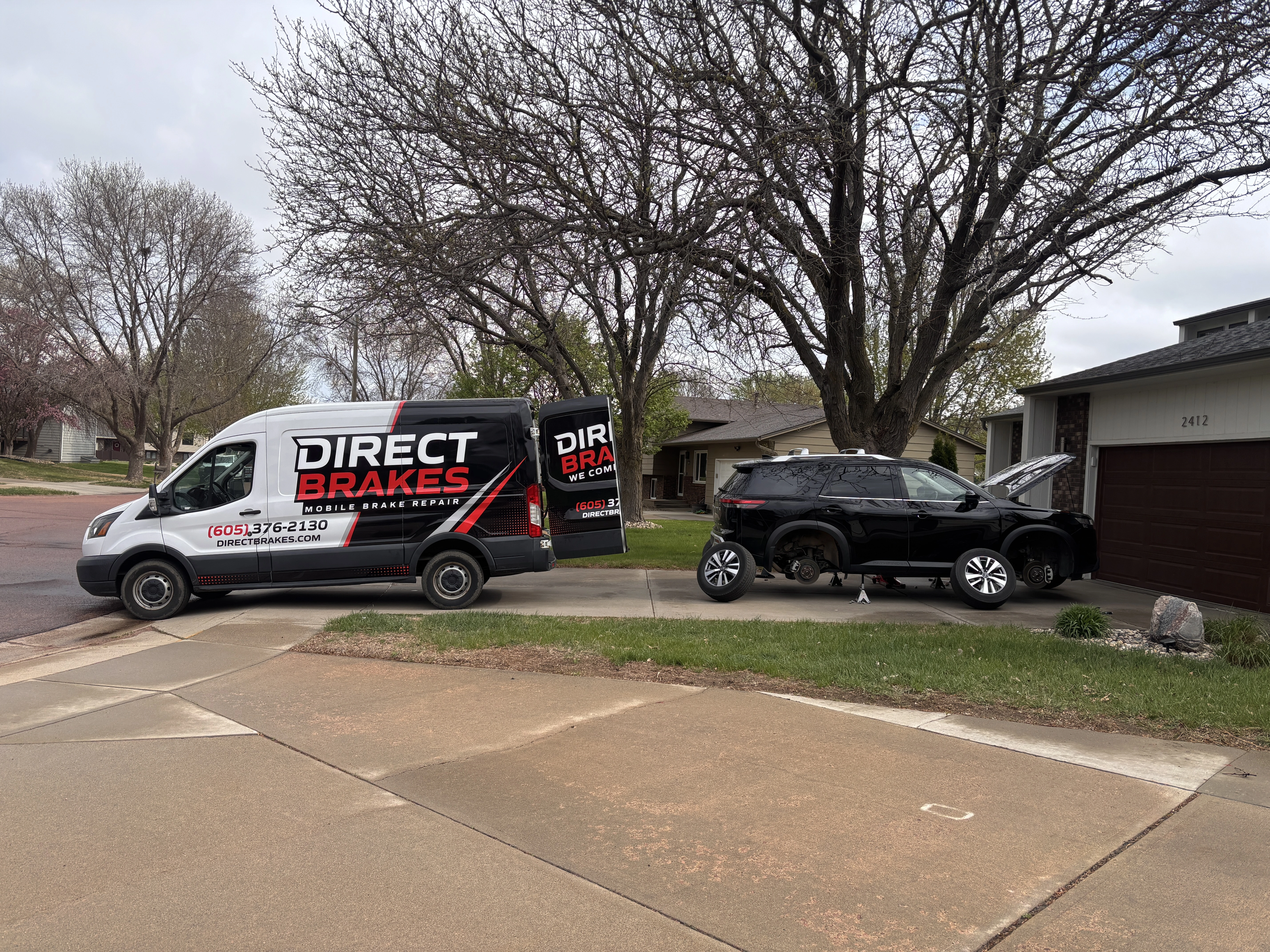 Direct Brakes technician performing mobile brake pad replacement in Omaha customer driveway